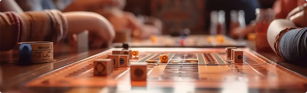 Het gezelschap zit aan tafel en speelt een bordspel met dobbelstenen.