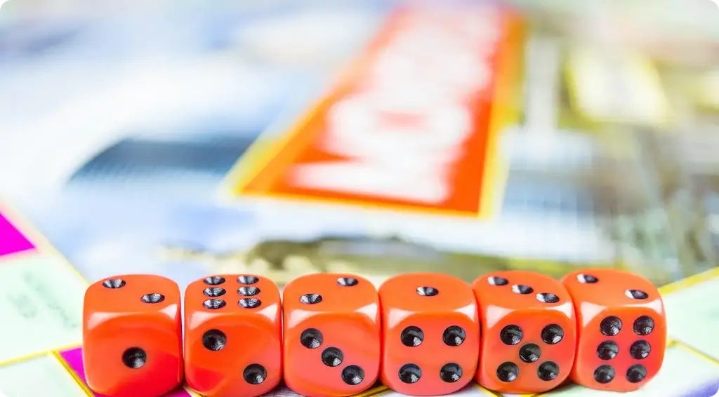 Rode blokjes staan op een rij tegen de achtergrond van het Monopoly-spel.